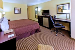 Cette chambre comprend un lit et un bureau avec un ordinateur. dans l'établissement AmericInn by Wyndham Council Bluffs, à Council Bluffs