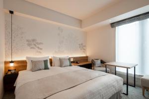 a bedroom with a bed and a desk and a window at Tokyu Stay Shinjuku Eastside in Tokyo