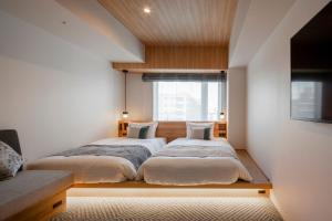 a bedroom with two beds and a window at Tokyu Stay Shinjuku Eastside in Tokyo