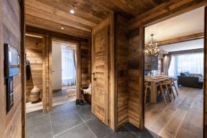 een woonkamer met houten wanden en een eetkamer bij Alaska Lodge by Alpine Resorts in Val dʼIsère