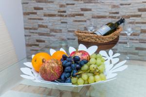 un plato de fruta en una mesa con una botella de vino en Apartman Neve, en Dubrovnik