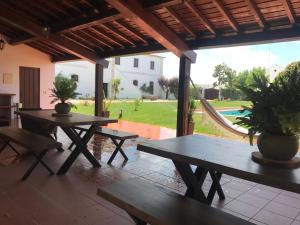 patio con tavoli da picnic e vista su un cortile di Quinta da Atela ad Alpiarça