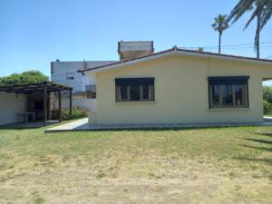 une petite maison blanche avec une cour dans l'établissement Chalecito hermoso, à La Paloma