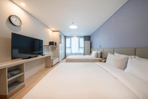 a hotel room with a large bed and a tv at SureStay Plus Hotel by Best Western Asan in Asan