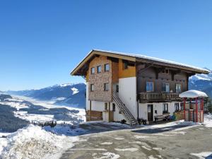 un edificio en la cima de una montaña cubierta de nieve en Apartment Tauernblick by Interhome, en Bramberg am Wildkogel