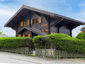 una casa con una valla delante de ella en Chalet Chalet Merymont by Interhome, en Villars-sur-Ollon