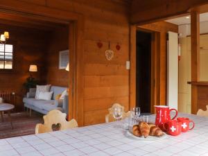 una mesa con un plato de cruasanes y copas de vino en Chalet Chalet Merymont by Interhome, en Villars-sur-Ollon