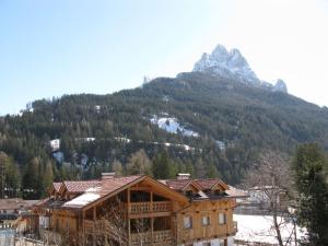 uma grande casa de madeira em frente a uma montanha em Apartment Cincelli - Catinaccio by Interhome em Pozza di Fassa