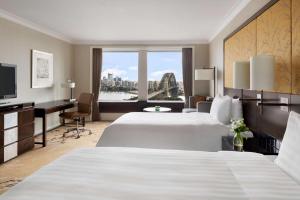 A bed or beds in a room at Shangri-La Sydney