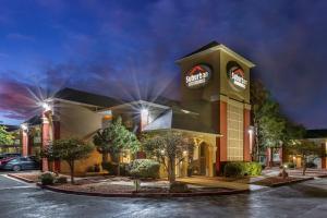 a hotel with a sign on the front of a building at Suburban Studios in Albuquerque