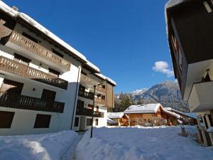 een gebouw in de sneeuw met bergen op de achtergrond bij Apartment Des Alpes-8 by Interhome in Canazei