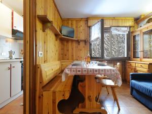 een keuken met een tafel in een kamer met houten wanden bij Apartment Des Alpes-8 by Interhome in Canazei