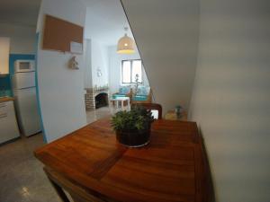 una cocina con una mesa de madera con una maceta. en Ahoy Porto Covo Hostel, en Porto Covo