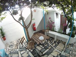 un patio con sillas, un árbol y una boca de incendios en Ahoy Porto Covo Hostel, en Porto Covo