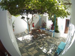 un patio con una mesa y un árbol en Ahoy Porto Covo Hostel, en Porto Covo