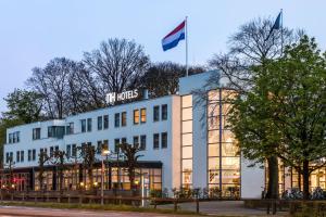 a building with a flag on top of it at NH Bussum Jan Tabak in Bussum