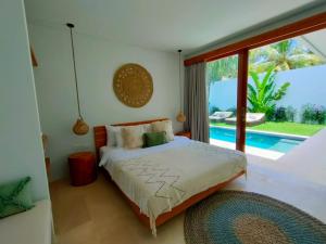 Schlafzimmer mit einem Bett und Poolblick in der Unterkunft Kalea Villas in Kuta Lombok