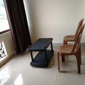 een kamer met 2 stoelen, een tafel en een raam bij HAVEN COTTAGE in Ooty