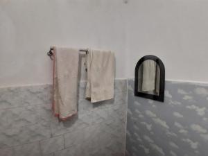 bagno con asciugamani bianchi e specchio di Sudha Kutir Puri a Puri