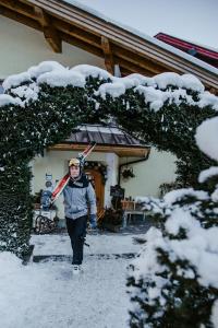 een vrouw loopt in de sneeuw met ski's bij Boutique Hotel Martha in Zell am See