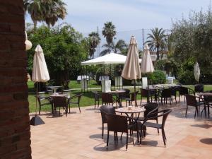 un patio con mesas, sillas y sombrillas en Mas Gallau, en Cambrils