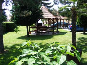 einen Pavillon mit einem Picknicktisch in einem Park in der Unterkunft Spengler Apartman in Harkány