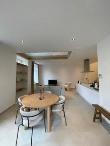 a kitchen and dining room with a wooden table and chairs at L'Apothèque - Résidence Le Cercle in Marche-en-Famenne