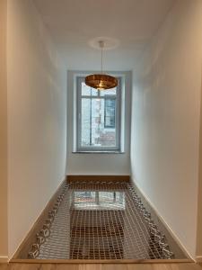 a empty room with a window and a metal grate at L'Apothèque - Résidence Le Cercle in Marche-en-Famenne