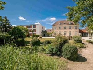 ibis Styles Dijon Sud Domaine De Beauregard 21600 Longvic في ديجون: منزل كبير وامامه حديقة