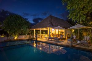 eine Villa mit einem Pool in der Nacht in der Unterkunft Komodo Garden in Nusa Lembongan