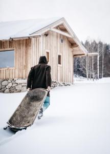 een man met een snowboard voor een hut bij Aparthotel & Wellness Knížecí cesta in Horní Planá