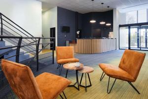 una hall con sedie, tavolo e scala di Sure Hotel by Best Western Nantes Beaujoire a Nantes