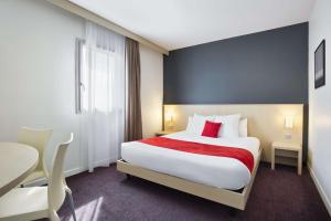 una camera d'albergo con un grande letto e un tavolo di Sure Hotel by Best Western Nantes Beaujoire a Nantes