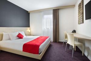 una camera d'albergo con letto e scrivania di Sure Hotel by Best Western Nantes Beaujoire a Nantes