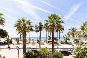 a view of a parking lot with palm trees and the ocean at A 20 metros de la playa in Sitges