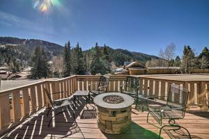 eine Terrasse mit Stühlen und einem Tisch auf einer Holzterrasse in der Unterkunft Red River Condo with Fire Pit half Mi to Slopes! in Red River