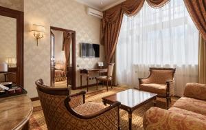 Premier Palace Hotel Kyiv في كييف: غرفة معيشة مع أريكة وطاولة