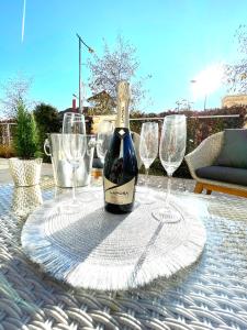 a bottle of wine sitting on a table with wine glasses at Spa Residence Carbona Royal Suites 1.11 in Hévíz