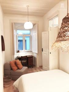 - une chambre avec un lit, un canapé et une fenêtre dans l'établissement Beach & Castle - Sines Apartment, à Sines