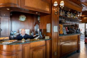 Een man aan een bar in een pub. bij Hotel Du Lac Menaggio in Menaggio