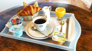 een dienblad met een kopje koffie en een bord eten bij Résidence Carouge Appart Hôtel in Brétigny-sur-Orge