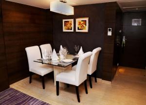 a dining room with a table and white chairs at Country Inn & Suites By Radisson Navi Mumbai in Navi Mumbai