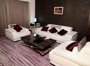 a living room with two white couches and a table at Country Inn & Suites By Radisson Navi Mumbai in Navi Mumbai