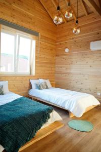 2 camas en una habitación con paredes de madera en Largo Bispo Boutique Hostel, en Horta