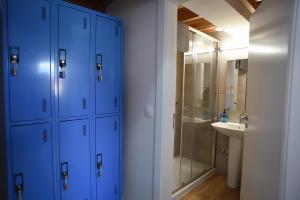 y baño con armarios azules, lavamanos y ducha. en Largo Bispo Boutique Hostel, en Horta