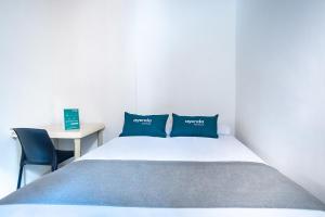 a small bedroom with a bed and a desk at Ayenda Acacia in Ibagué