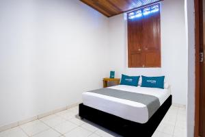 a bedroom with a bed with blue pillows at Ayenda Acacia in Ibagué