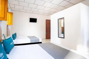 a hotel room with two beds and a tv at Ayenda Acacia in Ibagué