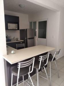 uma cozinha com uma mesa e cadeiras e um frigorífico em Marina Diamante Acapulco con todos los Servicios em Acapulco