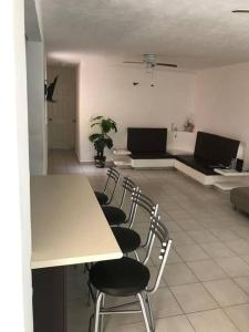 um quarto com uma mesa e cadeiras e um sofá em Marina Diamante Acapulco con todos los Servicios em Acapulco